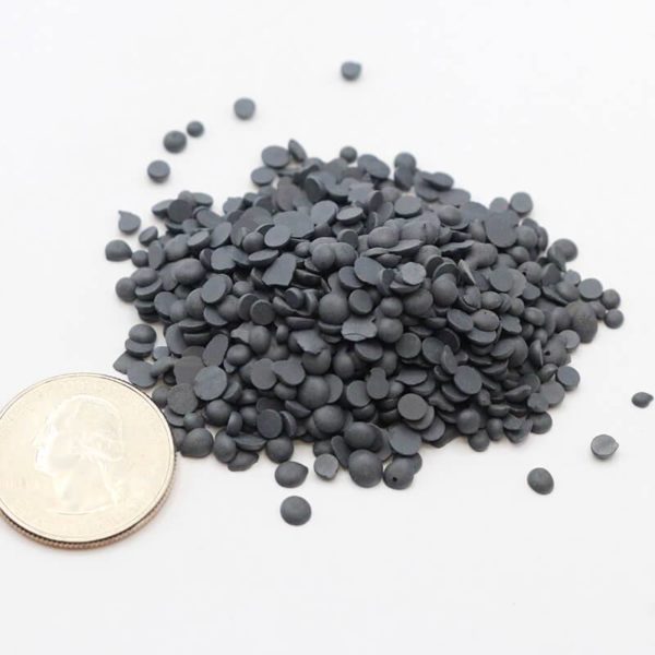 Iron granules piled next to american quarter for size comparison; granules approximately 1/20th the size of the quarter